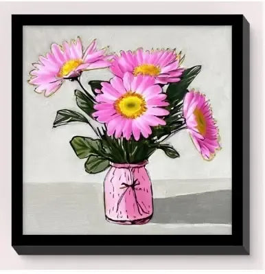 Framed wall art featuring vibrant pink daisies with yellow centers in a bright pink vase.