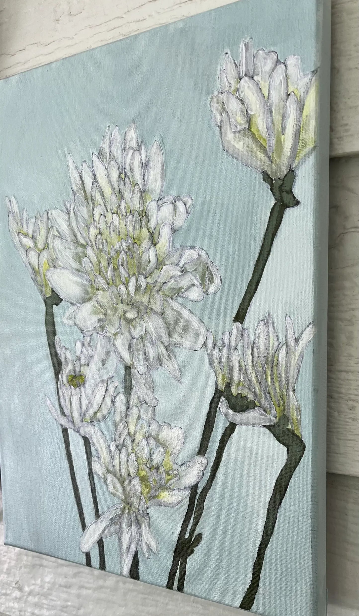 Side View of the central white multi-petaled flower with light green highlights in a serene white flower painting.