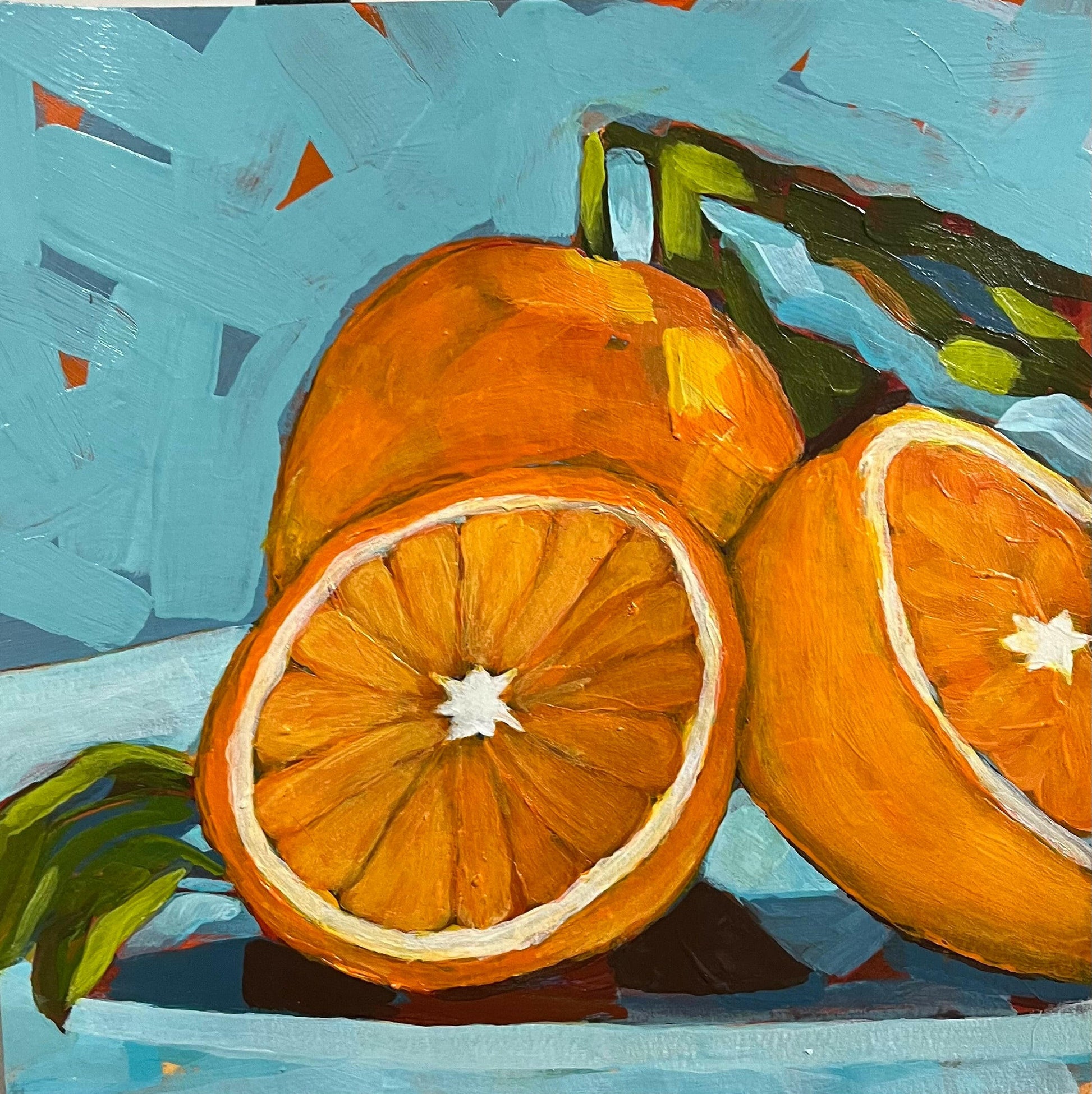 Vibrant still life artwork featuring bright orange citrus fruits, one whole and two halves, on art paper